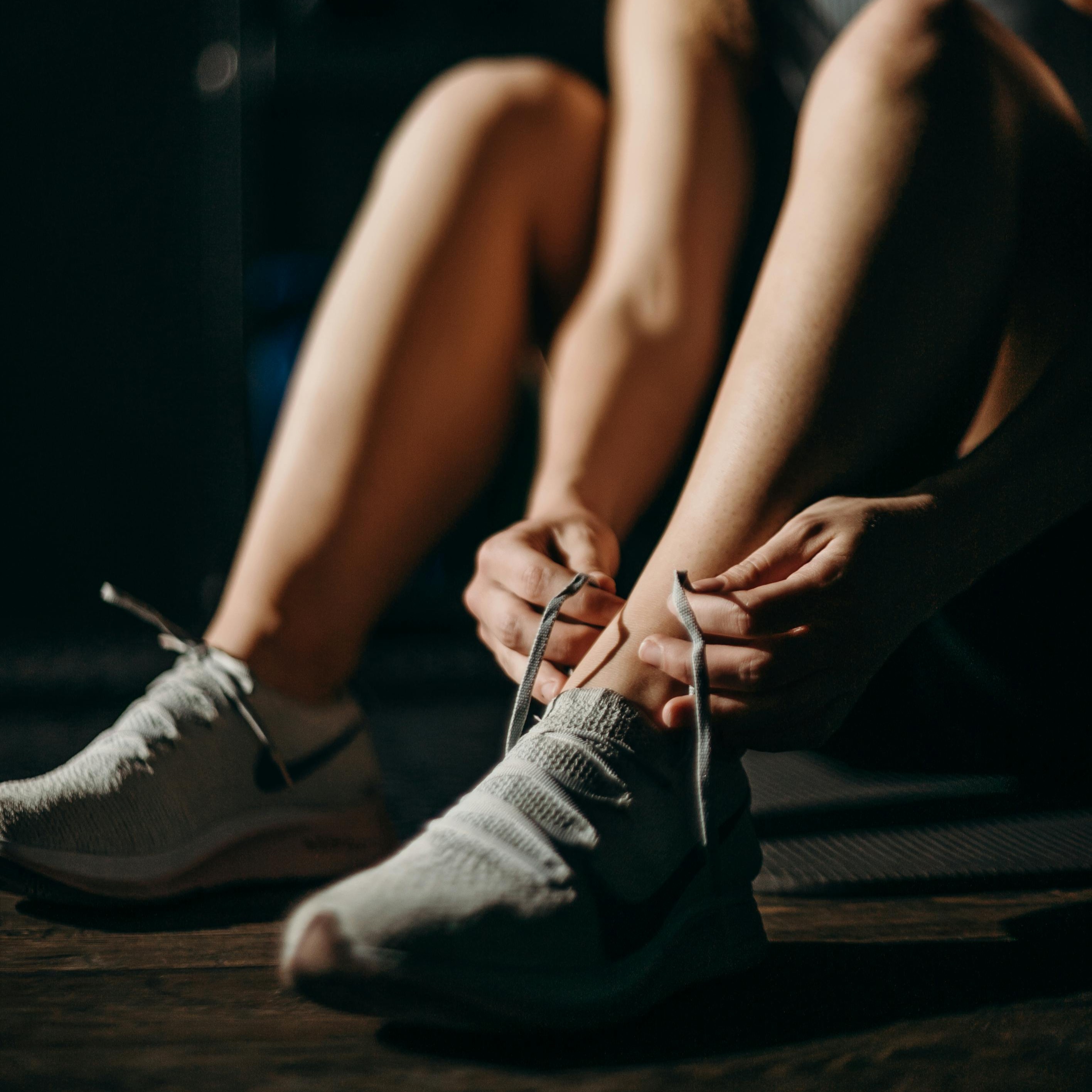 woman tying her shoe before a workout